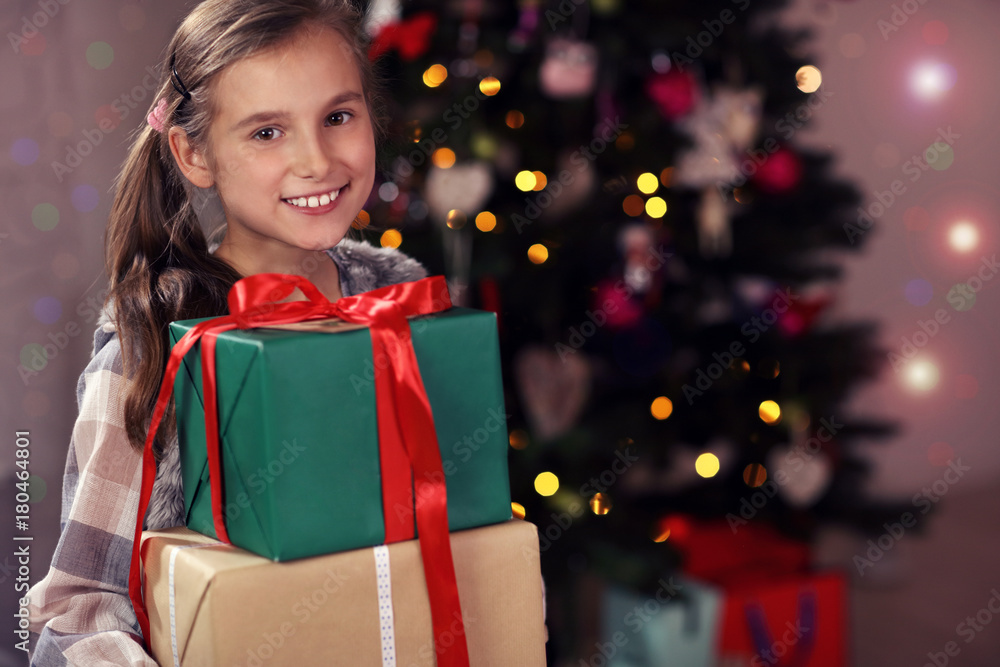 Happy girl posing with presents during Christmas time Happy girl posing with presents during Christmas time