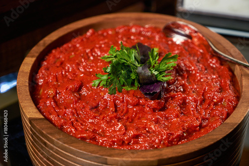 Tomato sauce with garlic and basil in a wooden bowl closeup