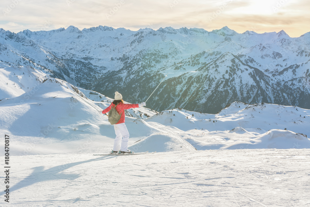 Happy skier woman enjoying the mountains view in the ski slopes