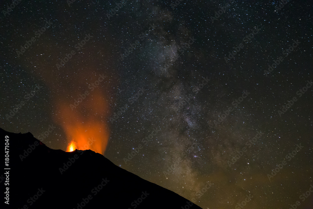 Erupting volcano Stromboli, Italy, at night with prominent Milky Way.