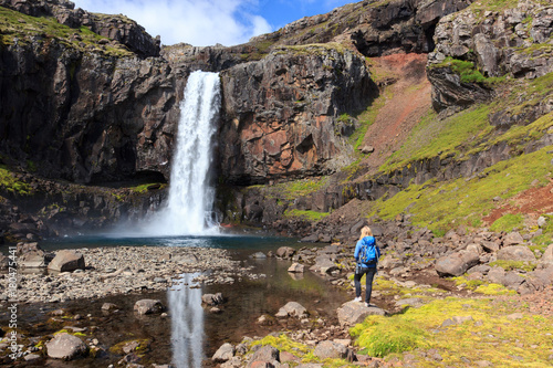 Hiker at waterfall in Iceland   Wanderer an einem Wasserfall in Island
