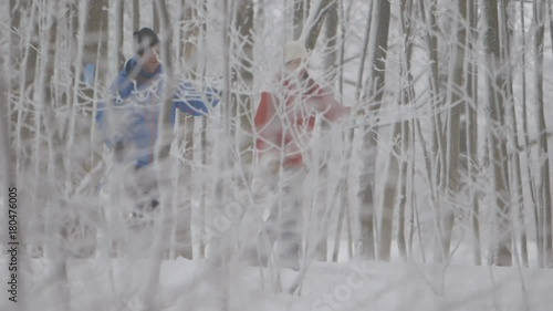 Two skiers pushing across the ground through the forest