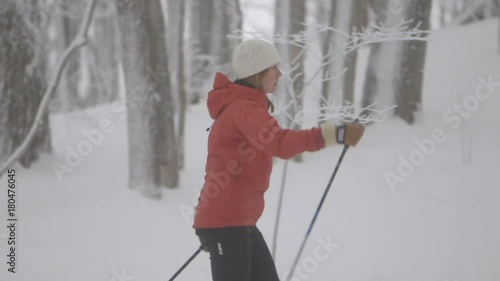 A skier pushing her way down a path with a man doing the same behind her