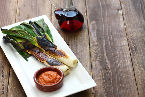 roasted calcots with romesco sauce for dipping, spanish catalan cuisine isolated on white background photo