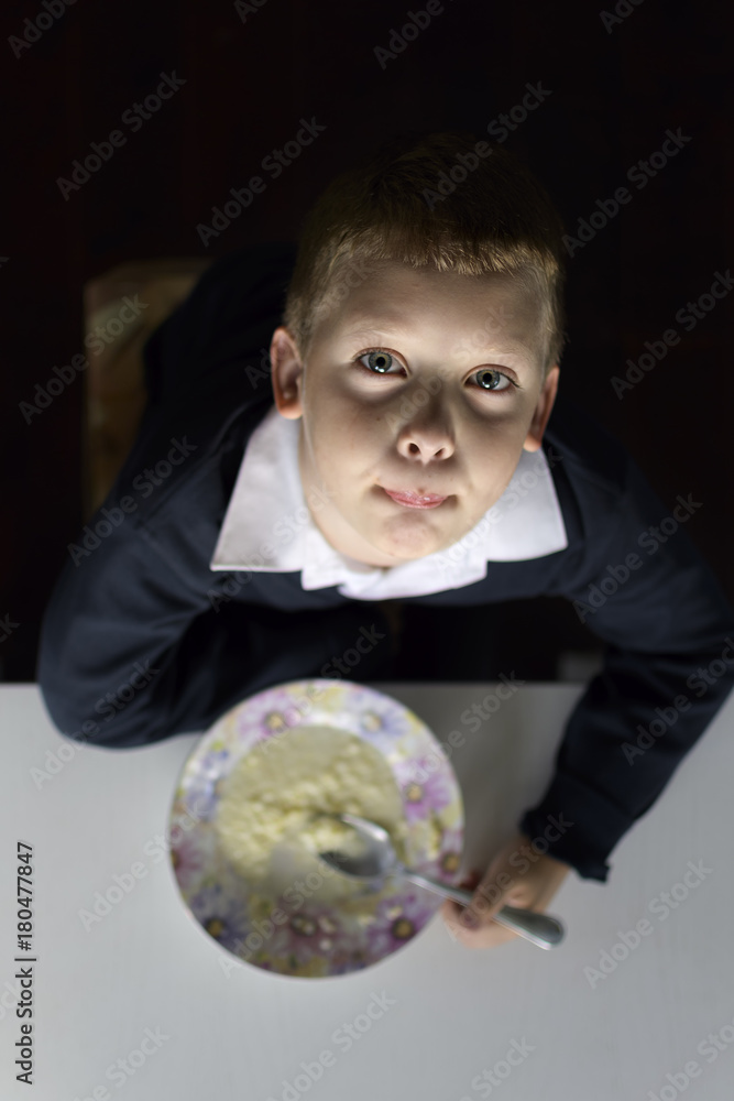 A young guy eats milk porridge. A young guy eats milk porridge.