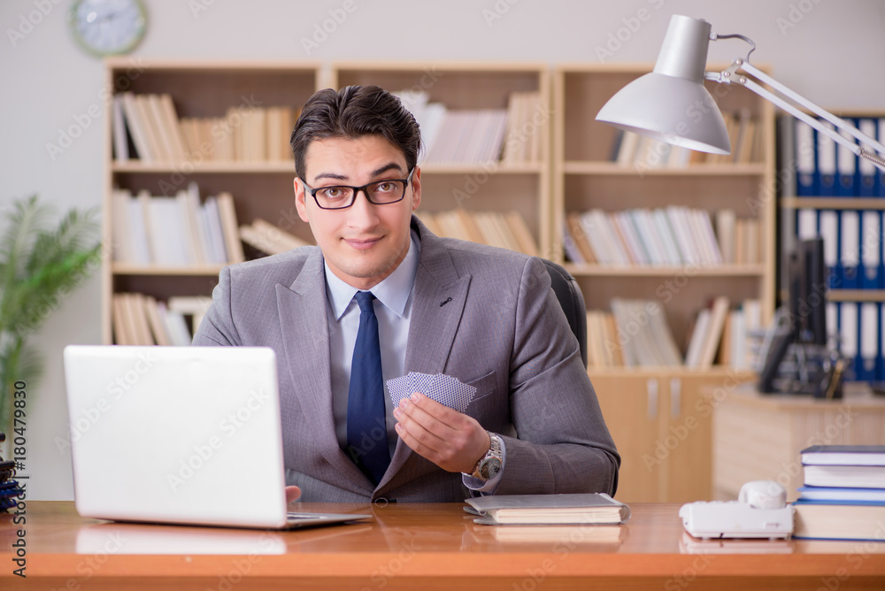 Businessman gambling playing cards at work Businessman gambling playing cards at work