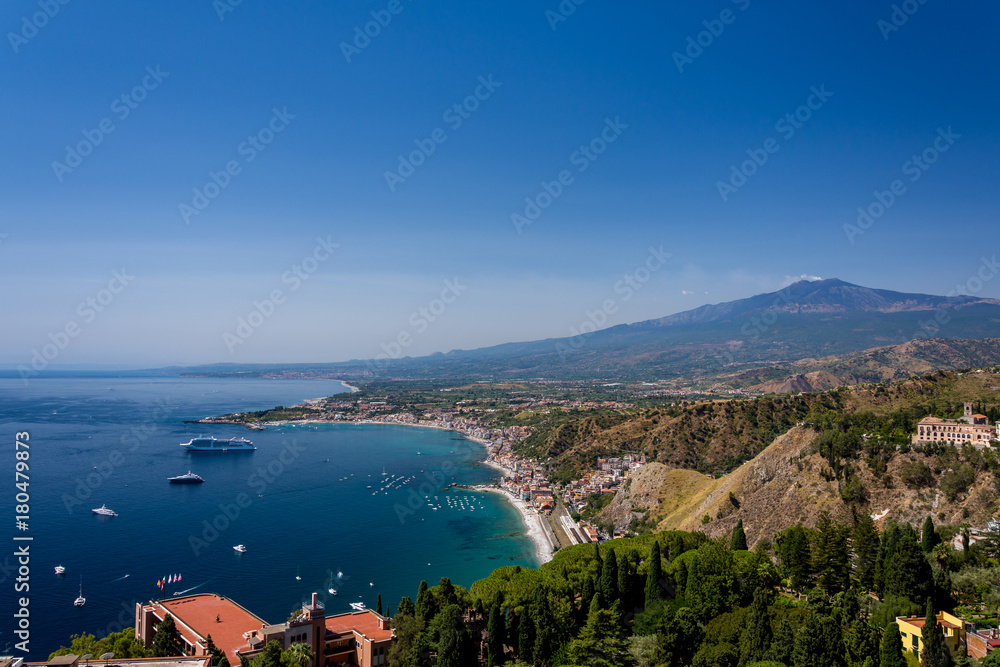 Fototapeta premium Taormina bay on a summer day with the Etna volcano in the background seen from the Greek theater of Taormina, Sicily, Italy