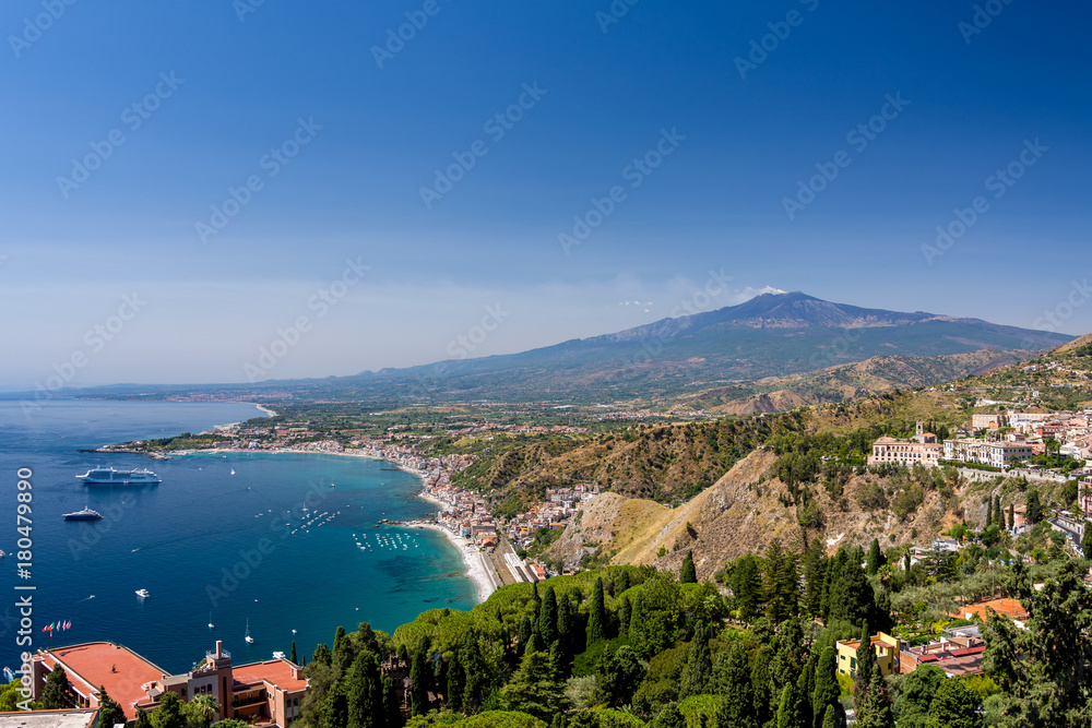 Taormina bay on a summer day with the Etna volcano in the background seen from the Greek theater of Taormina, Sicily, Italy