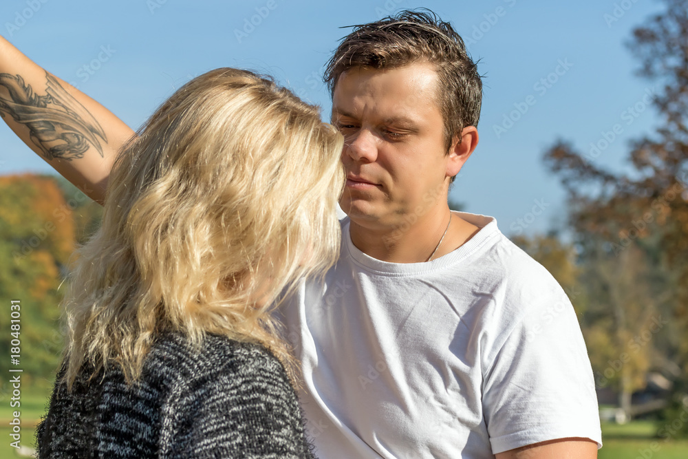 Fototapeta premium Young man is seriously looking at the blond woman standing back against the camera.