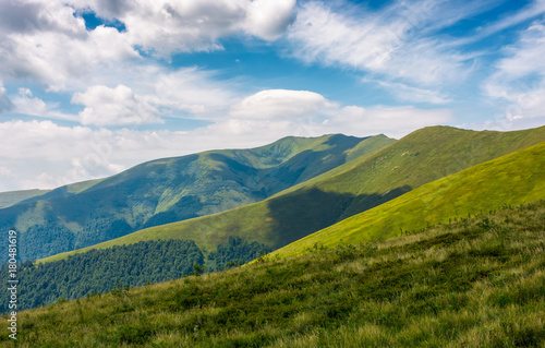 grassy slopes of mountain ridge under the cloudy sky. gorgeous summer nature scenery