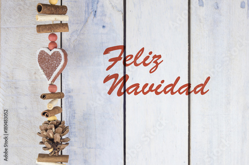 Christmas decoration on a wooden background with text in Spanish "Feliz Navidad