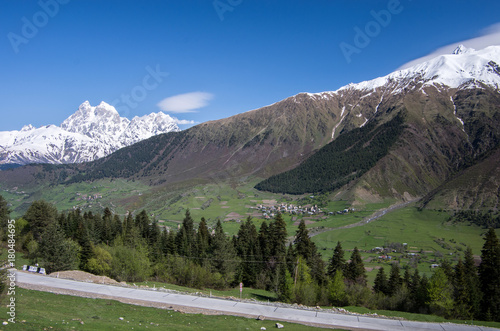 Concrete road in the background of snow-capped mountains. Caucasus.