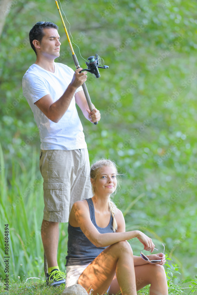 Φωτογραφία young couple fishing on the banks of the pond