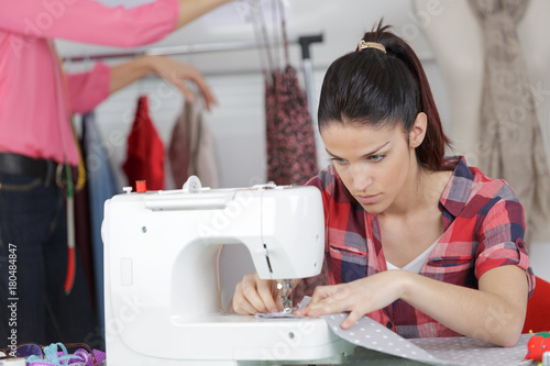 young woman is sewing cloth with sewing machine photo