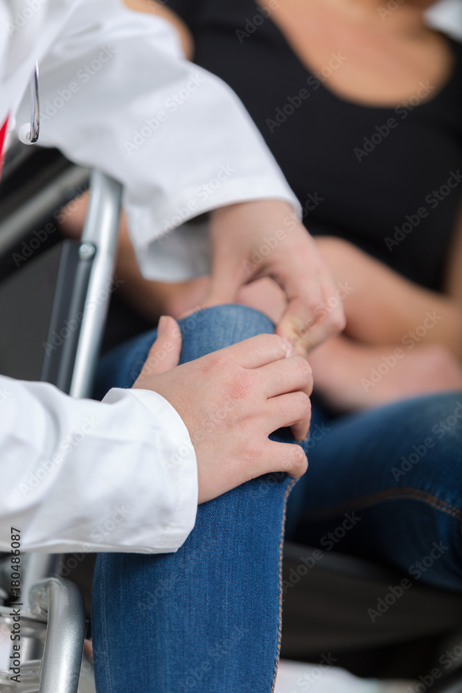 male orthopedic doctor examining womans knee in clinic male orthopedic doctor examining womans knee in clinic