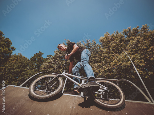 Bmx rider performing tricks at skatepark.