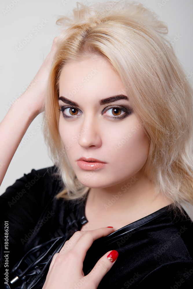 Blonde with bright makeup and a hand in her hair on white isolate closeup Blonde with bright makeup and a hand in her hair on white isolate closeup