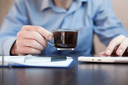 Man drink coffee and using tablet.