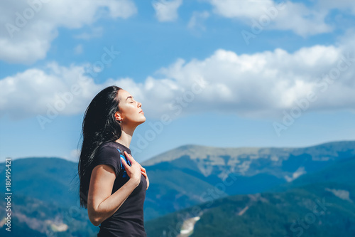 brunette girl on the top of the mountain enjoying fresh air
