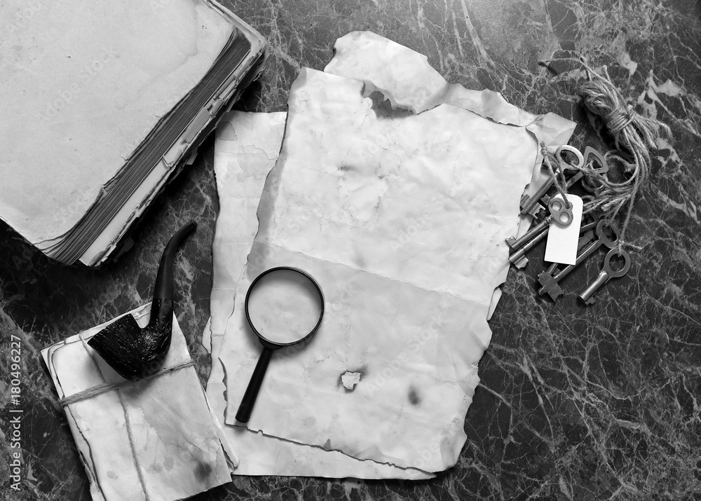 papers and book on detective work table with tools 
