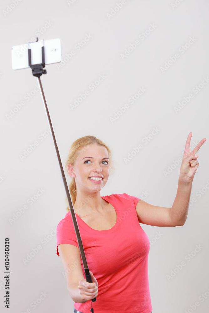 Woman taking picture of herself, phone on stick Woman taking picture of herself, phone on stick