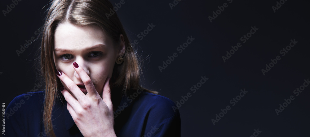 Portrait of a young woman looking in fear (Gestures, body language, psychology)