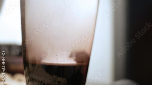 Dissolving medical tablet drops into water glass on bedstand photo