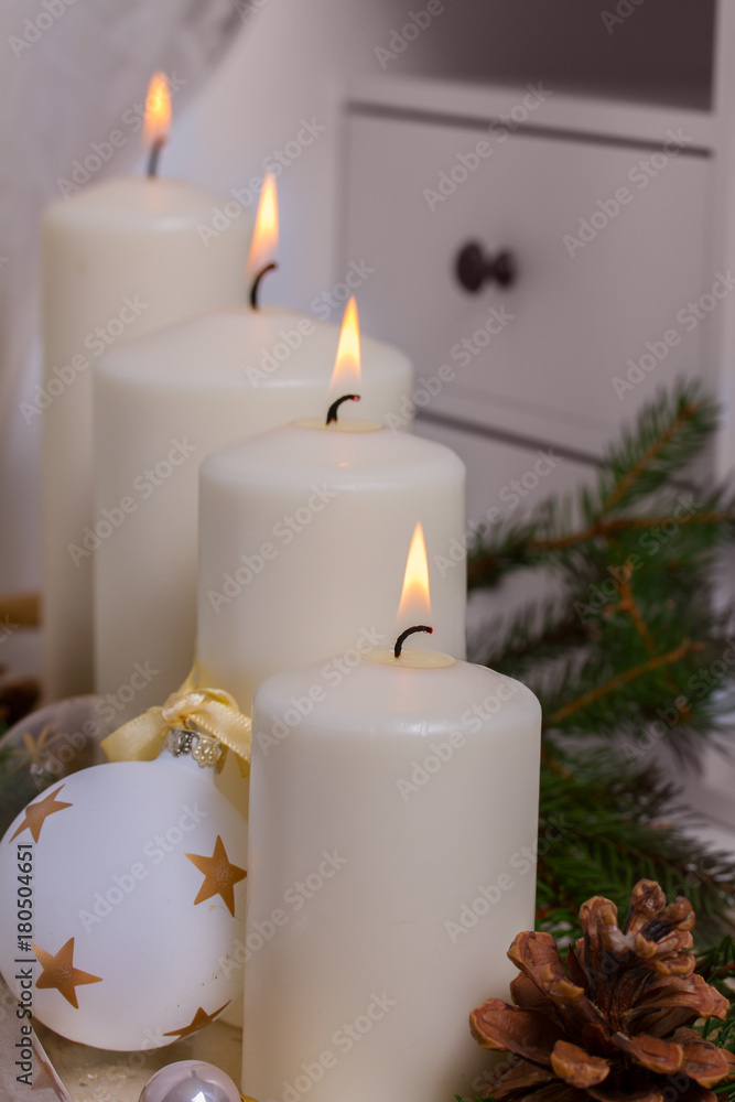 Four White burning advent candles with christmas decorations Four White burning advent candles with christmas decorations