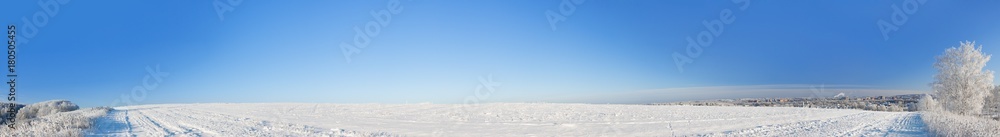 rural winter landscape panorama with a field, snow, forest, city and blue sky rural winter landscape panorama with a field, snow, forest, city and blue sky