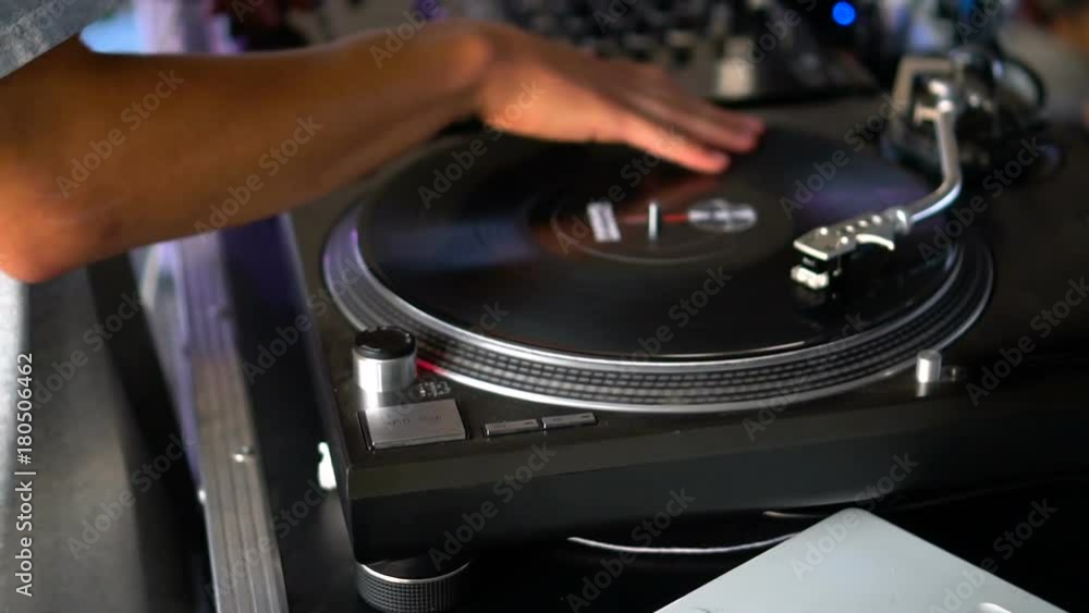 Mix and scratch, hands of a DJ on vinyl and mixer knobs. Slow motion 120 fps. Shooting with gimbal. Sunset. Mix and scratch, hands of a DJ on vinyl and mixer knobs. Slow motion 120 fps. Shooting with gimbal. Sunset.