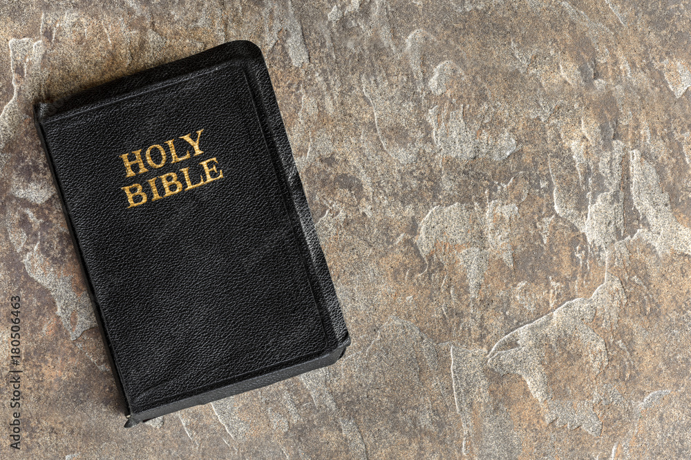 Fototapeta premium Old Bible Closed Top View over Stone Background