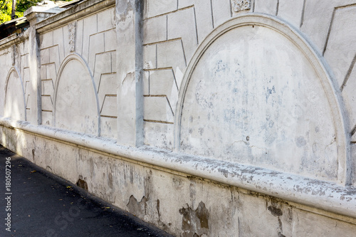 Brick wall. old peeling white paint exfoliates from rough cracked wall. Cracks, scratches, cleaning old paint and plaster on background of old cement wall. old wall of cement stone, in perspective photo