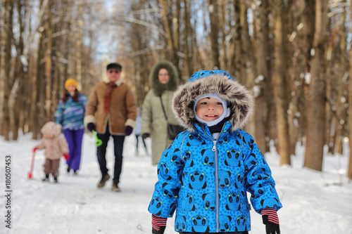 Kid running in winter park and have fun with family