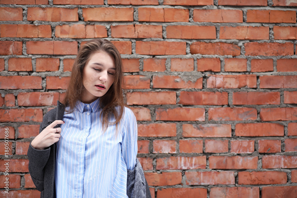 Young beautiful girl near red brick wall posing Young beautiful girl near red brick wall posing