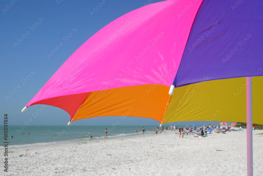 colorful beach umbrella dominates beach scene