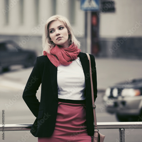 Young fashion business woman walking in city street