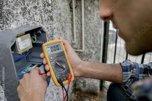 Electrician using a voltmeter device photo