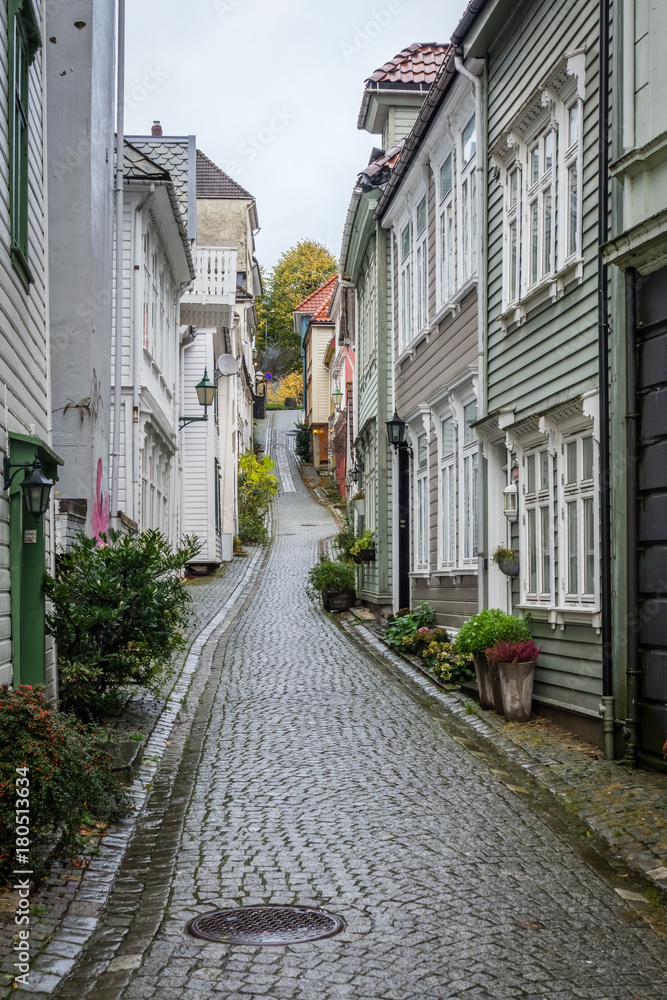 Narrow cobble stoned streets between traditional colorful houses in the old part of Bergen