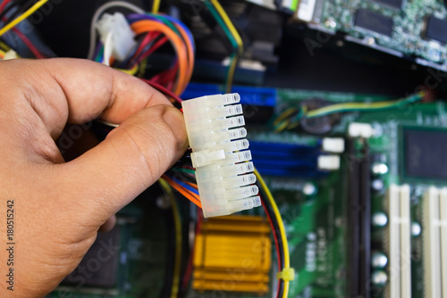 First person view hand holding ata/ide data cables on motherboard background. photo