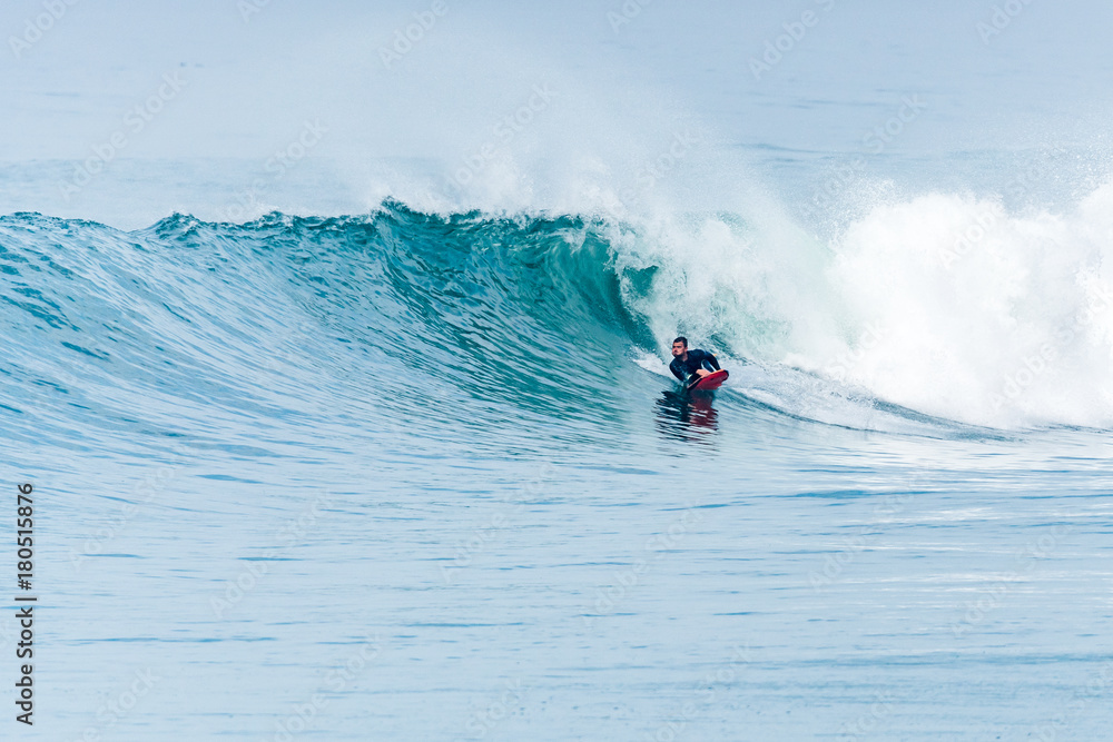 Naklejka premium Bodyboarder surfing ocean wave