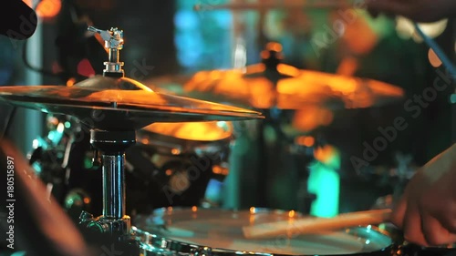 Young man playing electronic drums on stage. Concert. Neon light. Live music background. Drum kit on stage lights performance.Festival and show background. Slow motion