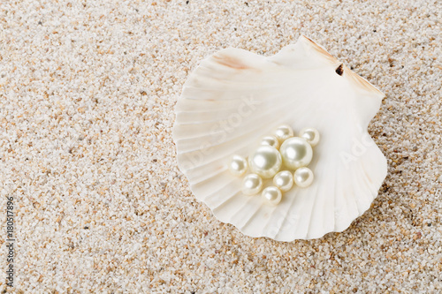 Multiple pearls in sea shell on sand