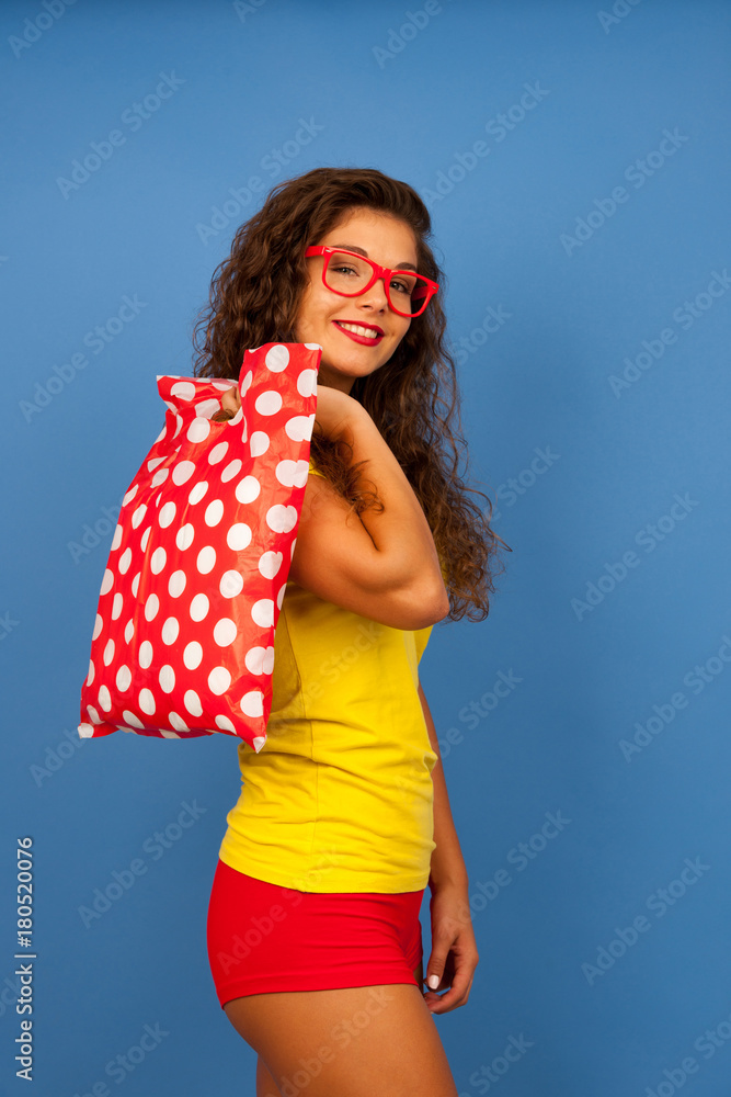 Veautiful young woman with shopping bags and credit card over blue background Veautiful young woman with shopping bags and credit card over blue background