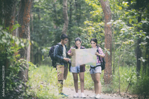 Asian Group of young people Hiking with friends backpacks walking together and looking map and taking photo camera by the road and looking happy ,Relax time on holiday concept travel © tuiphotoengineer