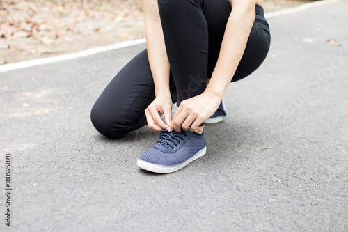 young woman runner tying shoelaces , sport concept