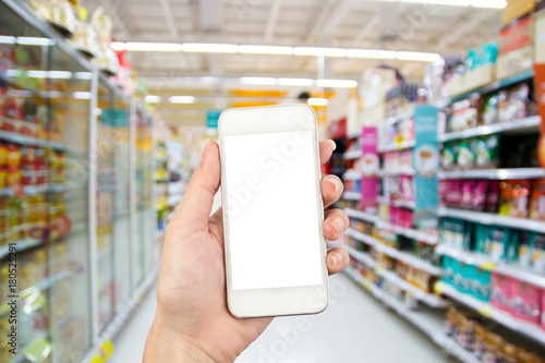young woman hand using smart phone on Supermarket blur background