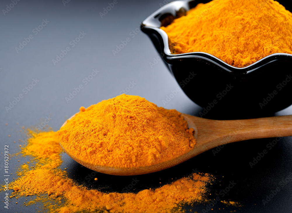 Turmeric powder on black background. Turmeric powder on black background.