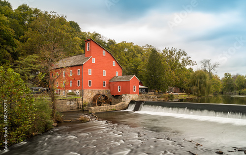 The historic Red Mill in Clinton NJ with people fishing in the river. The village also decorated for halloween as  photo taken in Mid October