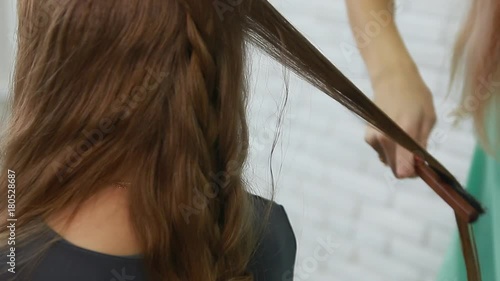 Professional Hair Dresser Used Hair Curler Iron for brunette Hair at beauty salon