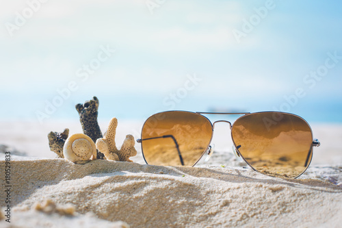 Obraz na płótnie Sunglasses and Coral on the sand. w salonie